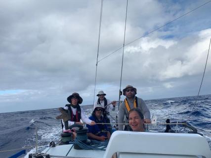 Crew wearing harnesses and flotation mid-ocean